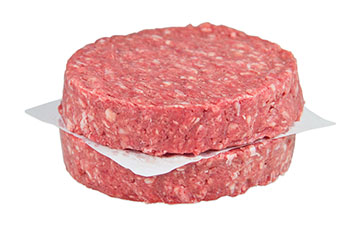 2 raw grass-fed beef burger patties, stacked with parchment between them